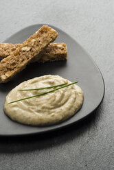 Hummus und Brotscheiben auf Teller garniert - RAMAF00039