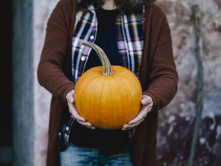 Woman's hands holding big pumpkin - RAMAF00062