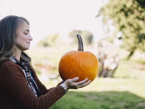 Stolze Frau mit großem Kürbis, lizenzfreies Stockfoto