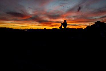 Silhouette eines Wanderers, der den Sonnenuntergang in den französischen Alpen genießt - AURF02375