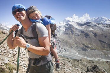 Vater wandert mit Sohn in Babytrage Rucksack in Schweizer Alpen, Zermatt, Kanton Wallis, Schweiz - AURF02434
