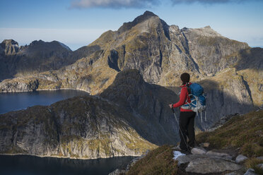 Female hiker takes in view of mountains from trail to Munken, Moskenes├©y, Lofoten Islands, Norway - AURF02435