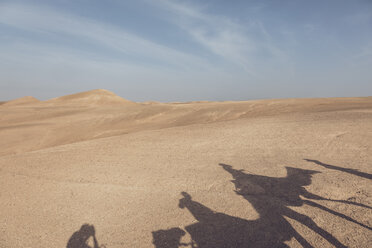 Marokko, Schatten einer Karawane mit Kamelen und Touristen auf Sand - MMAF00512