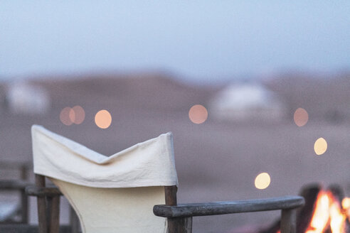 Marokko, leerer Stuhl am Lagerfeuer in der Wüste - MMAF00514