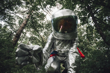 Spaceman exploring nature, examining plants in forest - VPIF00534