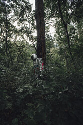 Spaceman exploring nature, looking at plants in forest - VPIF00542