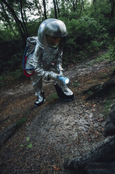 Spaceman exploring nature, using a torch - VPIF00550