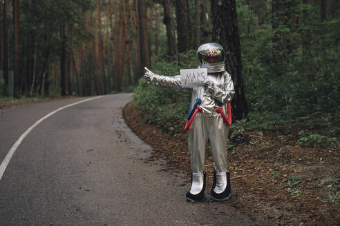 Raumfahrer, der per Anhalter zum Mars fährt, steht auf einer Straße im Wald - VPIF00553