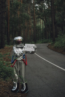 Raumfahrer, der per Anhalter zum Mars fährt, steht auf einer Straße im Wald - VPIF00555