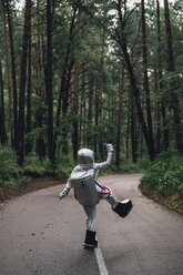 Spaceman exploring nature, standing on road in foreat - VPIF00561