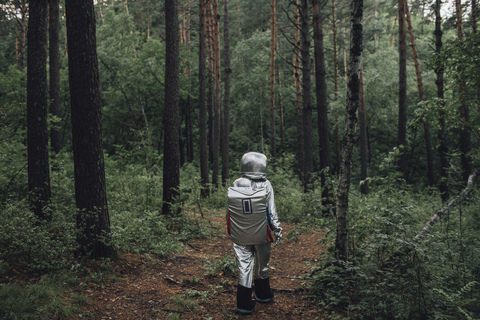 Raumfahrer erkundet die Natur, geht im Wald spazieren, lizenzfreies Stockfoto