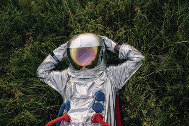 Spaceman exploring nature, relaxing in meadow - VPIF00576