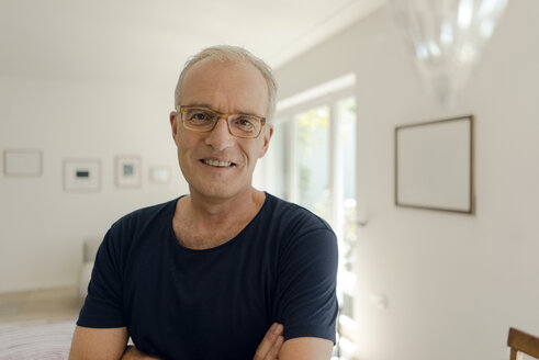 Portrait of a smiling mature man at home - KNSF04596