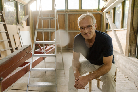 Portrait of a confident mature man sitting in his workshop stock photo
