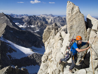 Mann klettert auf hohen Granitkamm, Sierra Nevada - AURF02483