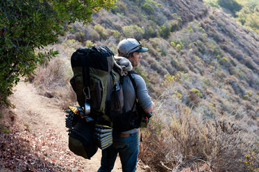 Man hikes with heavy pack. - AURF02484
