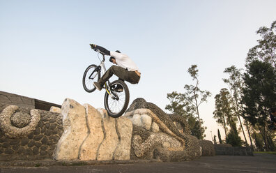 One man riding his bike doing trial at the Chapultepec Park in Mexico City, Mexico. - AURF02539