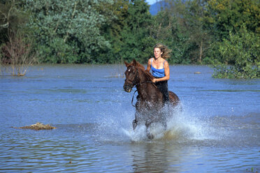 Susan Haslam gallops her horse through deep water. - AURF02596
