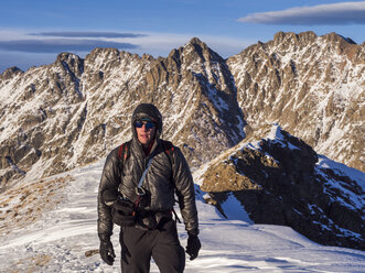 Ein Wanderer steht auf einem hohen Bergrücken mit Blick auf die Gore Range im White River National Forest, Colorado. - AURF02675