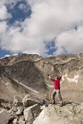 Ein Mann hebt beim Wandern in den Medicine Bow Mountains in der Nähe von Centennial, Wyoming, die Arme in den Himmel. - AURF02679