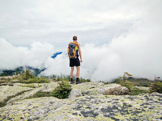 A man looks out over the clouds from the summit of Baldface Mountain, New Hampshire - AURF02688