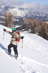 A male skier celebrates after skiing a deep powder run at Big Sky Resort in Big Sky, Montana. - AURF02711