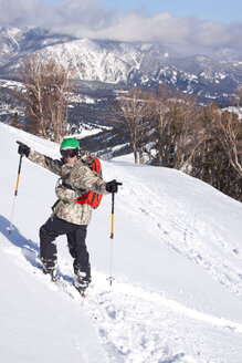 Ein männlicher Skifahrer jubelt nach einer Tiefschneeabfahrt im Big Sky Resort in Big Sky, Montana. - AURF02711