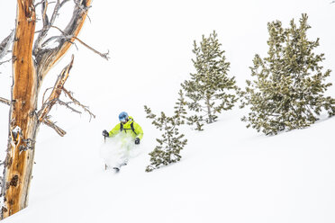 Ein männlicher Skifahrer mit einem Rucksack auf Skiern im Tiefschnee im Big Sky Resort in Big Sky, Montana. - AURF02727