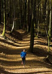 Ein männlicher Sportler posiert in einem Wald. - AURF02730