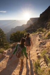 Two young women hikers hiking down a trail. - AURF02805