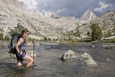 Frau überquert Evolution Creek auf dem John Muir Trail - AURF02820