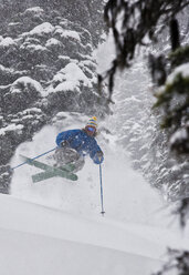 Junger Mann beim Skifahren im frischen Pulverschnee während eines Schneesturms im Island Lake Resort, Fernie, BC, Kanada. - AURF02855