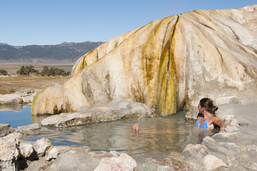 Woman soaks in Eastern Sierra hot springs, California - AURF02872