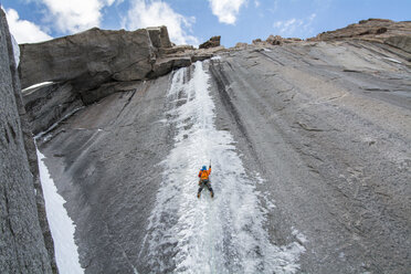 Ein Kletterer führt eine schwierige Erstbegehung einer Eiskletterei im Frühherbst durch. - AURF02900