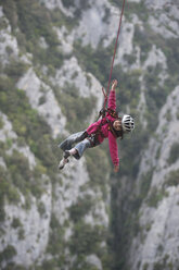 Ein 5-jähriges Mädchen genießt es, sicher an einem Kletterseil über ein tiefes Tal zu schwingen. - AURF02902