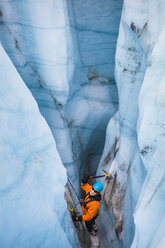 An ice climber swings her ice tools in a moulin on the Root Glacier in Wrangell-St. Elias National Park, Alaska. - AURF03003
