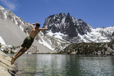 Cannonball time, ein junger Mann springt in einen einsamen See in der John Muir Wilderness, Eastern Sierras, Kalifornien. - AURF03046