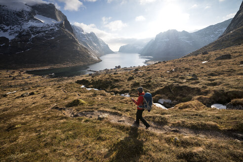 Wanderin beim Abstieg auf dem Weg zur Fähre im Dorf Kjerkfjord, Moskenes├©y, Lofoten Inseln, Norwegen - AURF03116