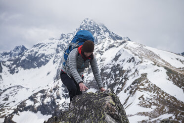 Female hiker scrambles over rock in Tatra mountains, Poland - AURF03117