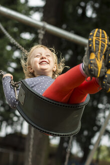 Begeistertes Kleinkind, das auf einem Spielplatz in Portland, Oregon, hoch schaukelt. - AURF03122