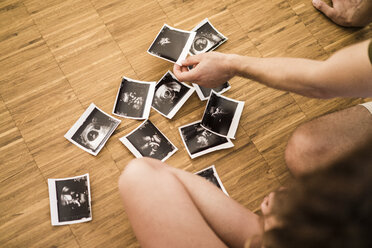 Couple with ultrasound scans on wooden floor - JOSF02544