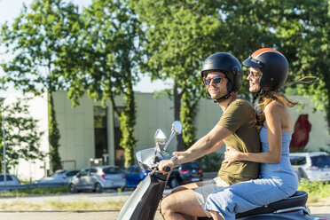 Happy couple riding motor scooter in summer - JOSF02557