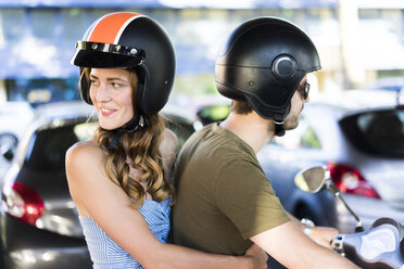 Glückliches Paar auf Motorroller in der Stadt - JOSF02562