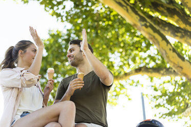 Glückliches Paar Eiscreme im Sommer High Fiving - JOSF02598