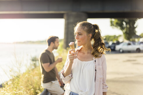 Paar isst Eis im Sommer am Flussufer - JOSF02600