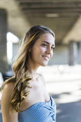 Portrait of smiling long-haired woman at underpass stock photo