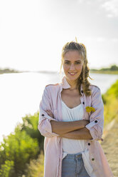 Portrait of smiling woman standing at the riverside in summer - JOSF02671