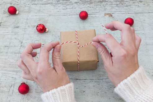 Frauenhände beim Einpacken von Weihnachtsgeschenken - JUNF01170