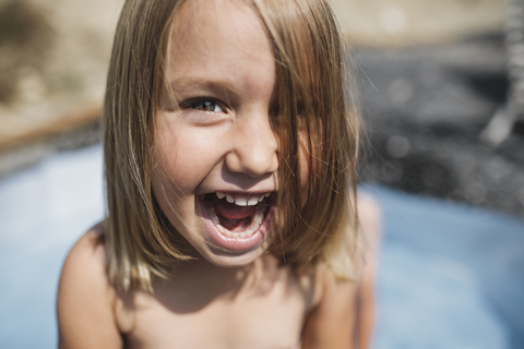 Porträt eines schreienden kleinen Mädchens, das Spaß im Pool hat, lizenzfreies Stockfoto