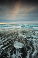 Glacial ice from Brei├░amerkurj├Âkull sits on the beach of the coast at Brei├░amerkursandur, Iceland, also known as the Jokulsarlon. - AURF03169